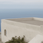 Une maison monochrome s’impose avec son toit-terrasse offrant une vue imprenable sur la mer