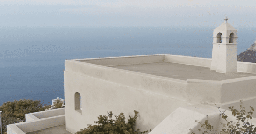 Une maison monochrome s’impose avec son toit-terrasse offrant une vue imprenable sur la mer